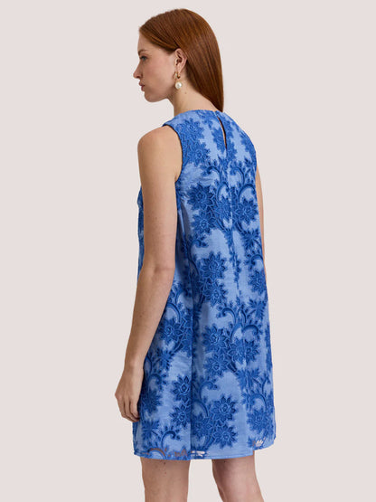A woman with long red hair wears the Hinson Wu Courtney Sleeveless Floral Motif Lace Dress in Lake Blue, standing sideways and looking ahead.