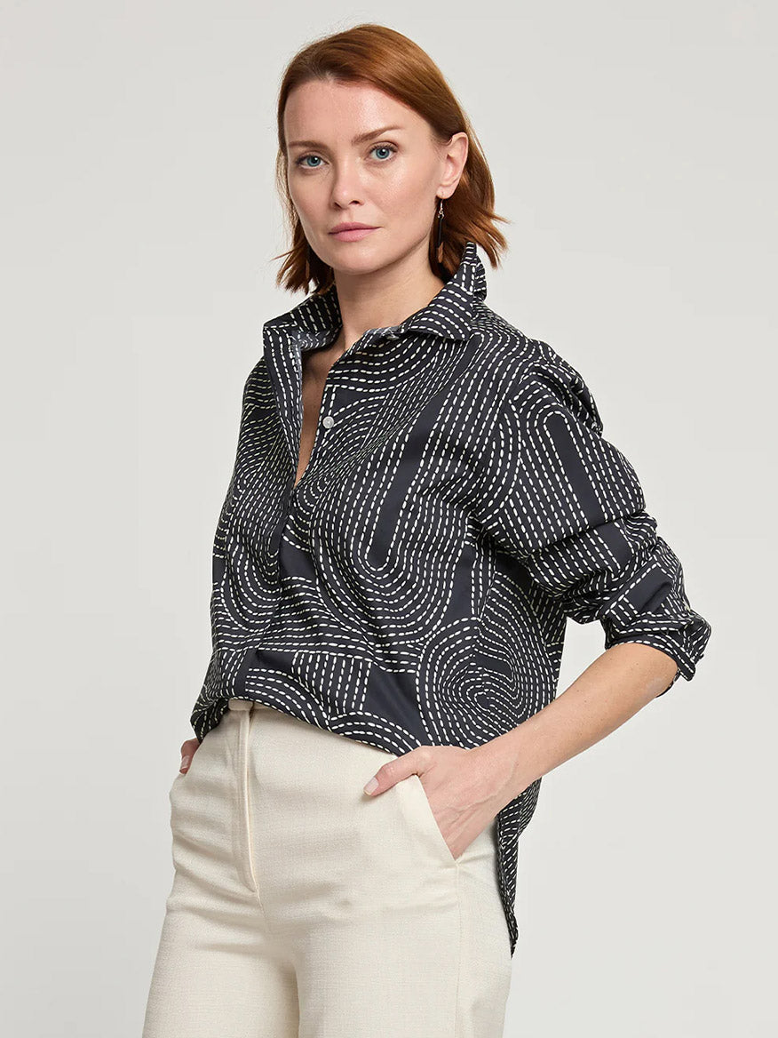 A woman with red hair stands with her hands in the pockets of her light-colored pants, wearing a Hinson Wu Halsey Long Sleeve Saddle Stitch Print Shirt.