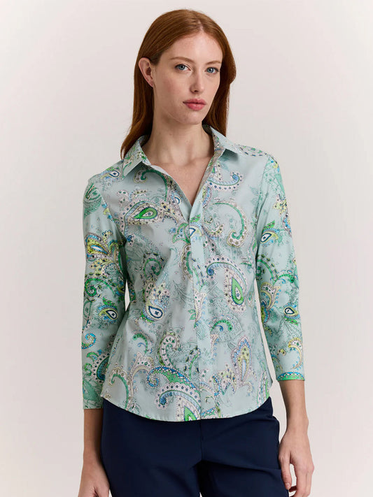A woman with long red hair wears the Hinson Wu Lizette 3/4 Sleeve Top in Dainty Paisley Print, a light blue refined cotton button-up with three-quarter sleeves, paired with dark pants against a plain light background.