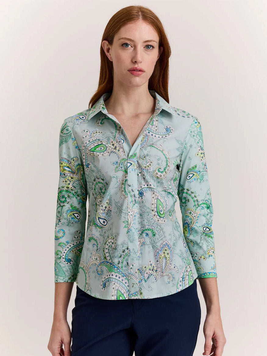 A woman with long red hair wears the Hinson Wu Lizette 3/4 Sleeve Top in Dainty Paisley Print and dark pants, standing against a plain light background.