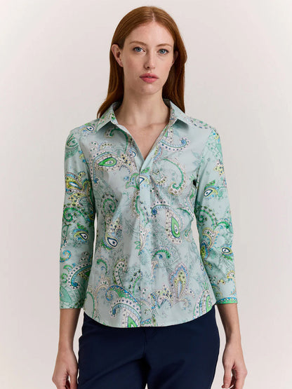A woman with long red hair wears the Hinson Wu Lizette 3/4 Sleeve Top in Dainty Paisley Print and dark pants, standing against a plain light background.