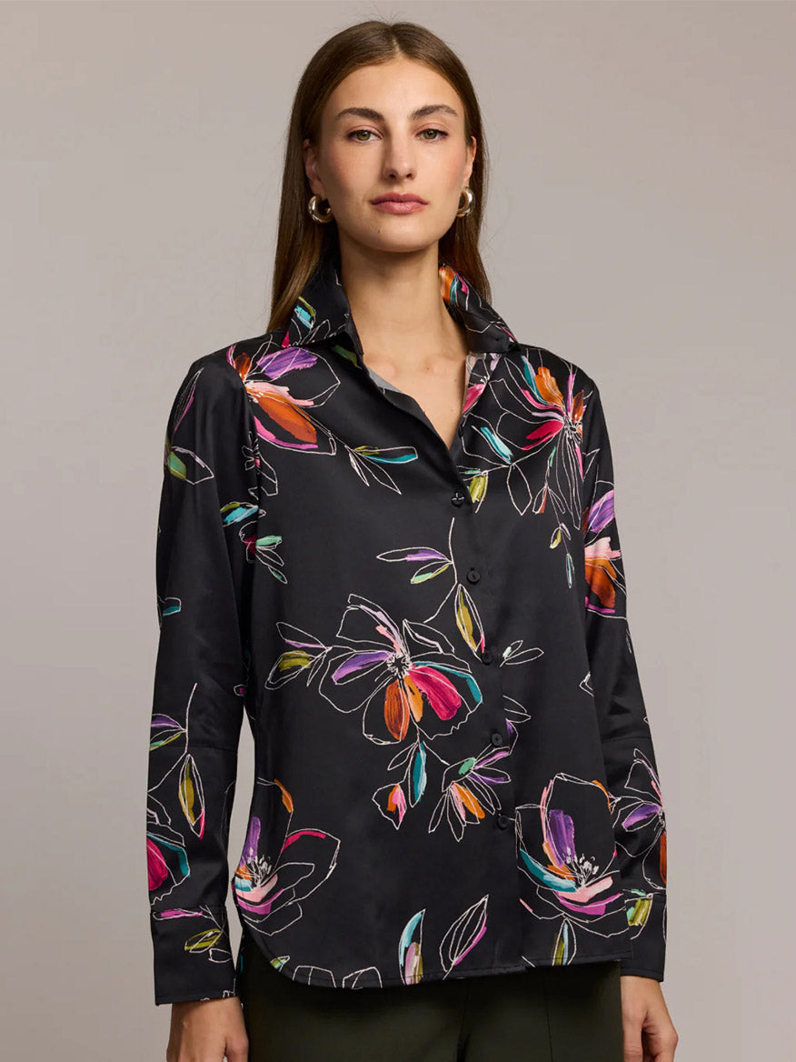 A woman stands against a plain background wearing the Hinson Wu Margot Long Sleeve Floral Stencil Shirt in Black paired with dark pants.