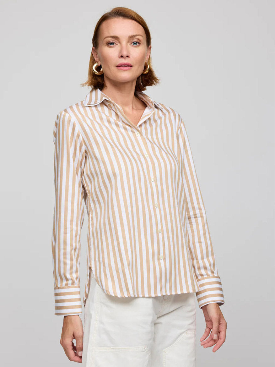 Against a plain backdrop, a person dons the Hinson Wu Margot Long Sleeve Stripe Shirt in Latte/White and white pants. Made from fine cotton fabric, this outfit boasts a polished look with timeless appeal.