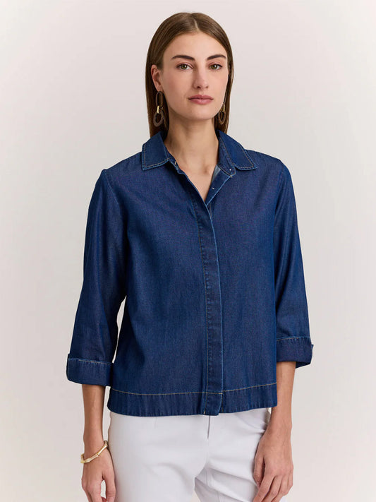 A woman stands facing forward, wearing the Hinson Wu New Xena 3/4 Sleeve Denim Shirt in Dark Denim and light-colored pants against a plain background.