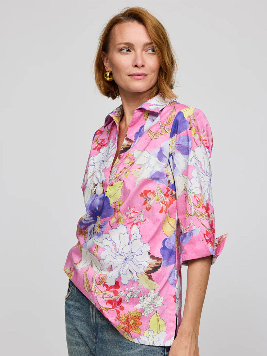 A person with short hair is wearing the Hinson Wu Vicky 3/4 Sleeve Watercolor Floral Shirt in Pink Combo and jeans, gazing to the left with a neutral expression.