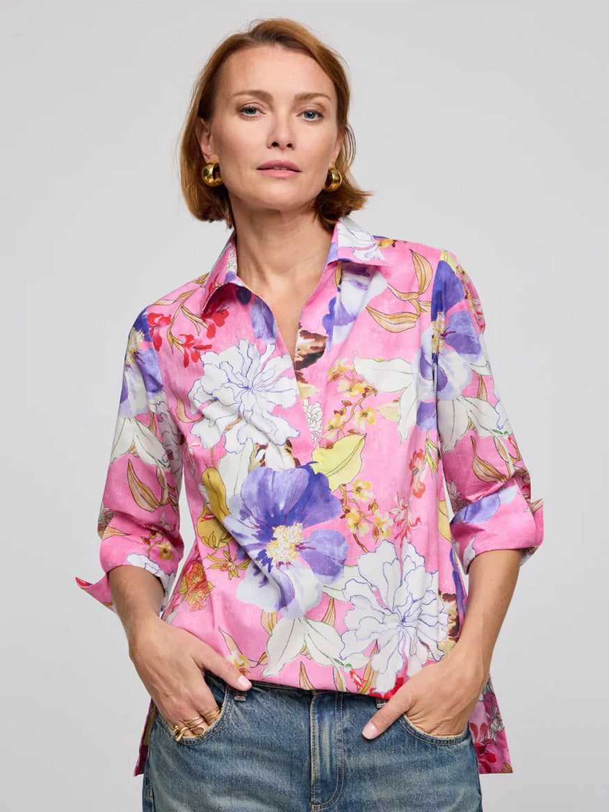 Wearing the Hinson Wu Vicky 3/4 Sleeve Watercolor Floral Shirt in Pink Combo, a person stands against a plain backdrop, pairing the exclusive print shirt with blue jeans.