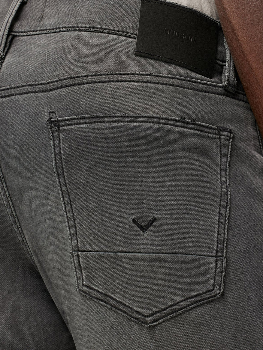 Close-up of a gray Hudson Blake Slim Straight Jeans in Ventura back pocket with a leather brand patch on the waistband.