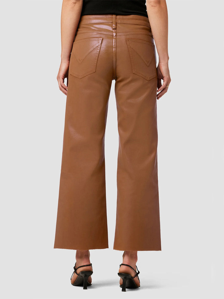 Woman wearing Hudson Rosie High-Rise Wide Leg Ankle Jean in Coated Caramel Cafe trousers and black open-toe heels.