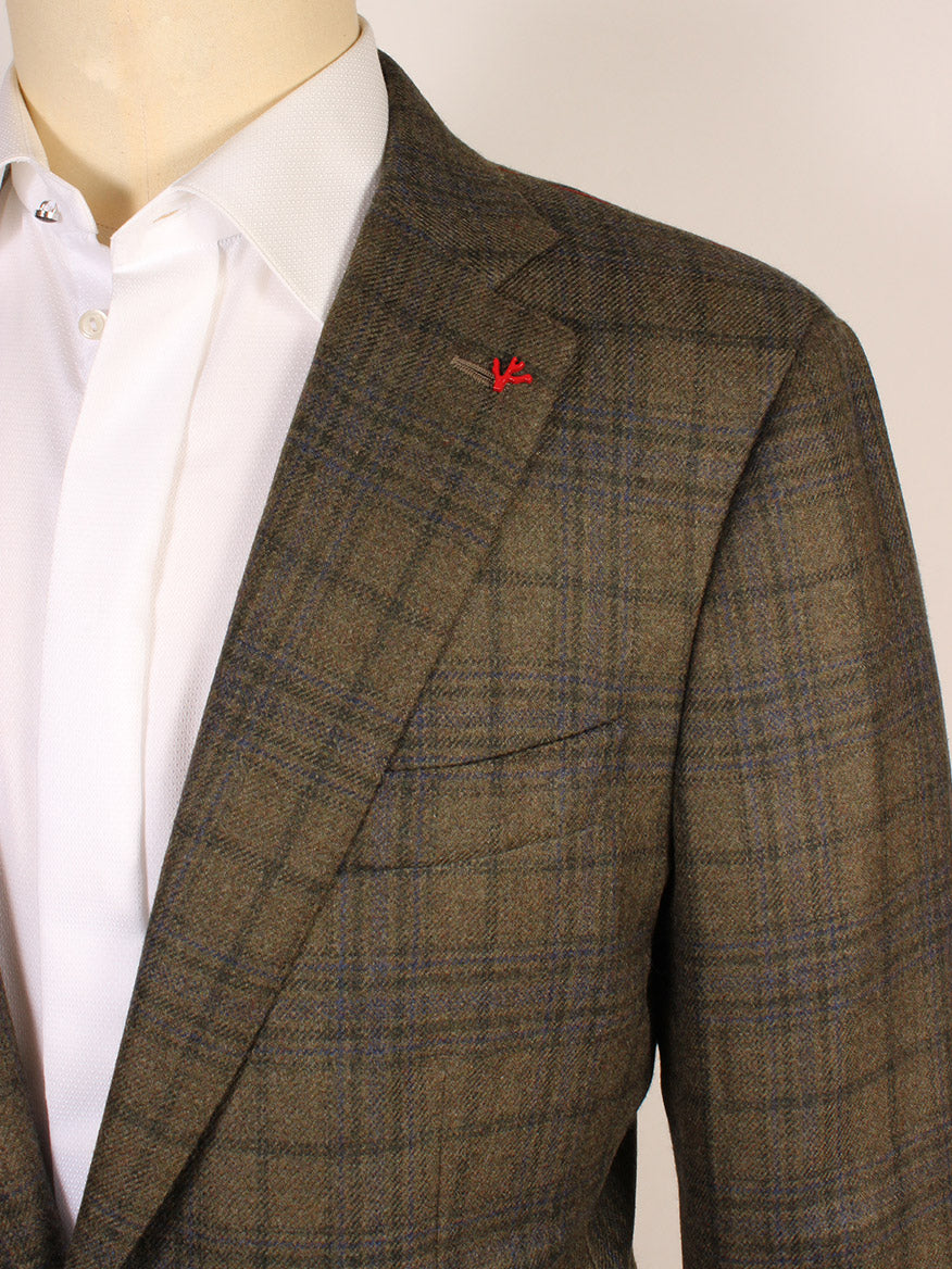 A close-up of a person wearing an Isaia Sanita Patch Pocket Sport Jacket in green plaid with a red lapel pin and a white dress shirt.