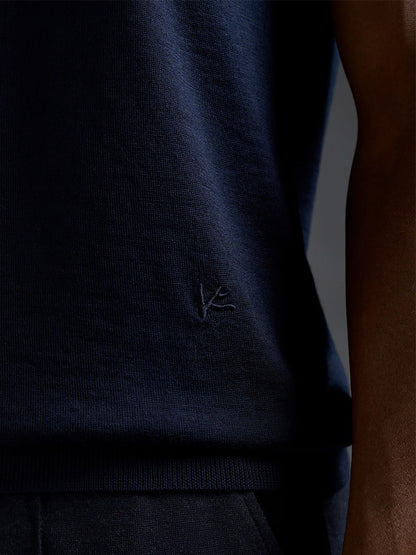 Close-up of a person wearing the Isaia Wool Cashmere Banded Tee in Navy, featuring ultrasoft knit fabric and a subtle embroidered logo near the hem.