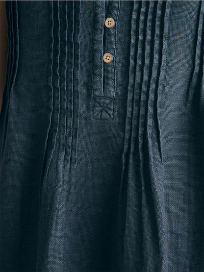 Close-up of a Faherty Brand Isha Basketweave Dress in Washed Black crafted from lightweight fabric, with two visible wooden buttons and stitched monogram initials "kk" near the bottom.