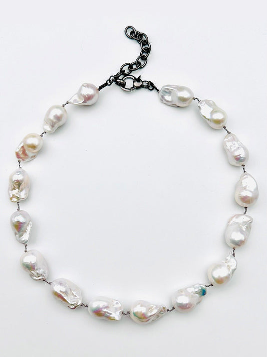 JMNYC Designs 18" AA Medium-Large White Freshwater Baroque Pearl Necklace, showcasing irregular white baroque pearls and finished with a sleek black adjustable chain clasp, elegantly displayed on a simple white background.