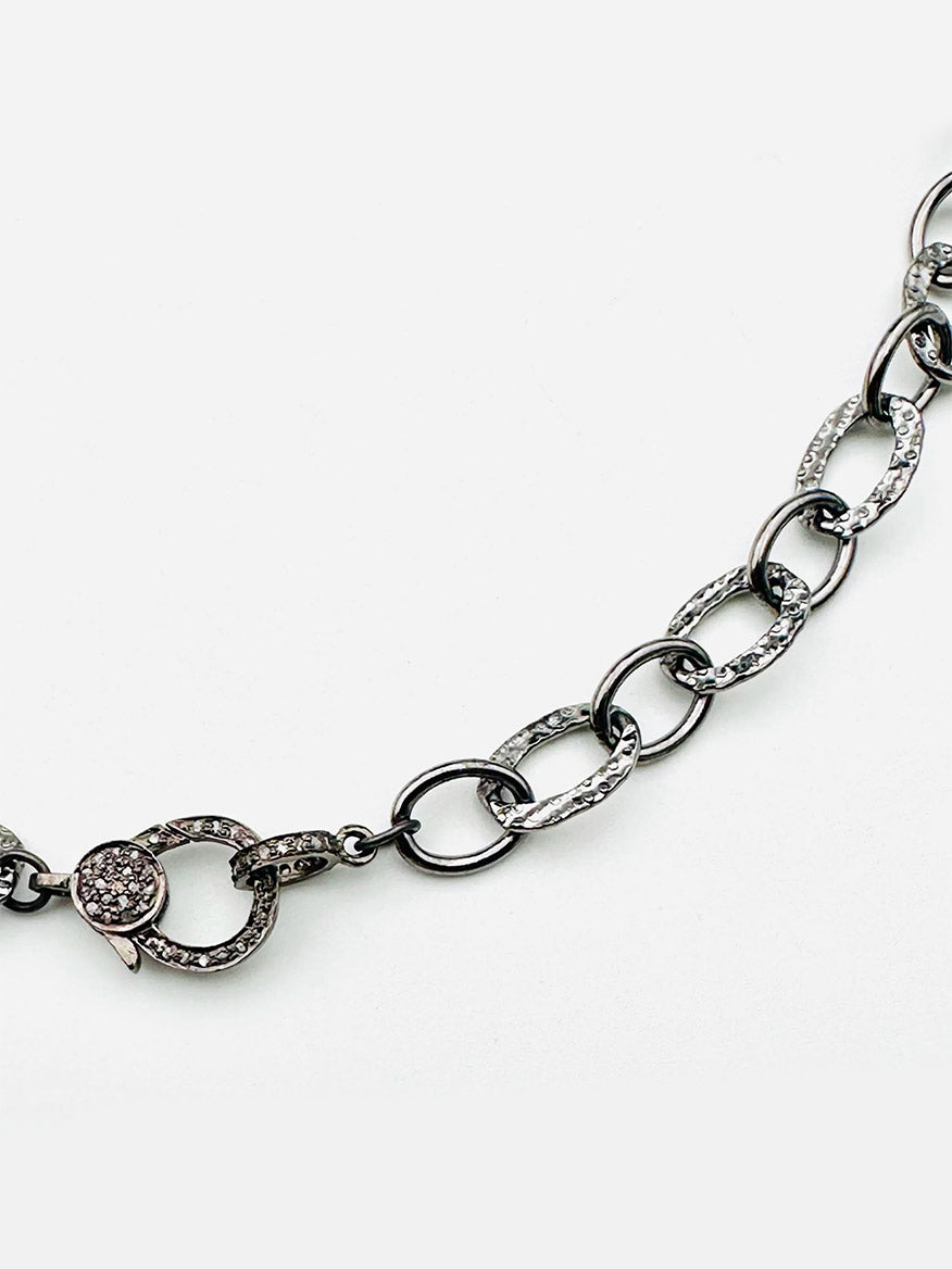 The JMNYC Designs 18" Hammered Oval Rhodium Plated Sterling Silver Chain features a diamond clasp and oval links, with several links and the clasp embellished with small clear crystals.