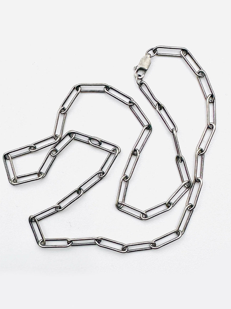 The JMNYC Designs 18" Sterling Silver Rhodium Plated Medium Paperclip Chain is laid out on a white background.