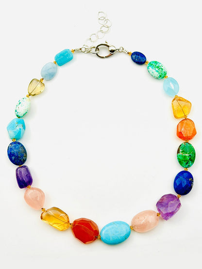Introducing the JMNYC Designs 18" Vivid Multi Stone Necklace—an eye-catching piece showcasing a vibrant mix of colorful, polished gemstone beads in an array of shapes and sizes. Finished with a sleek silver clasp, this necklace brings a playful splash of color to any ensemble.