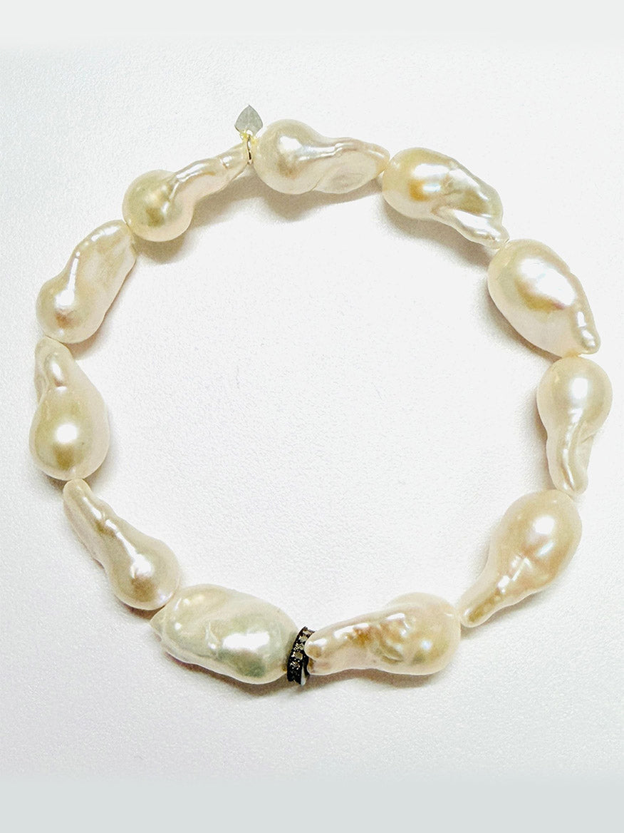 The JMNYC Designs AA Medium White Baroque Pearl with Diamond Rondelle, 7.25" bracelet showcases large, uniquely shaped white baroque pearls, each elegantly separated by a sparkling diamond rondelle and arranged in a graceful circle against a plain white background.