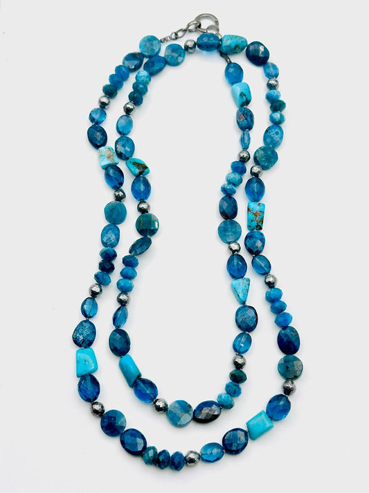 The JMNYC Designs 36" necklace features Apatite, London Blue Quartz, and Kingman Turquoise beads with a sterling silver clasp, elegantly displayed on a white background.