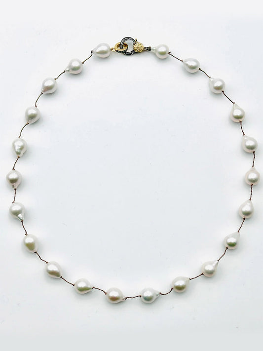 The JMNYC Designs Small White Baroque Pearl Necklace features irregular pearls on a thin cord with an 18" length and a two-tone vermeil & sterling silver diamond clasp.
