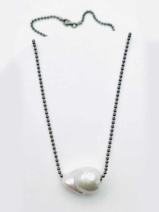 The JMNYC Designs Large White Baroque Pearl On Rhodium Sterling Silver Ball Chain 18" necklace features a single baroque pearl pendant on a rhodium-plated sterling silver chain, displayed on a white background.