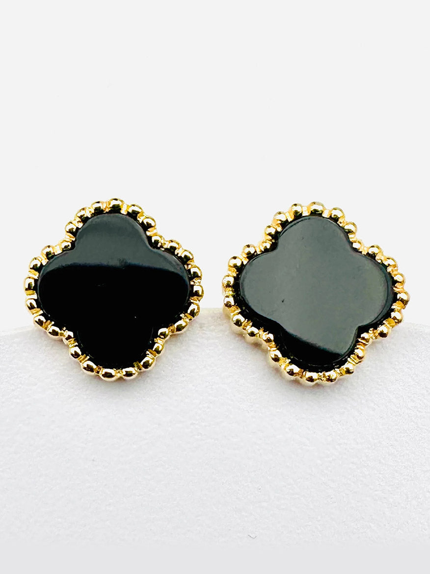 The JMNYC Designs Black Onyx Clover Vermeil Post Earrings, measuring .5", feature a black clover-shaped design with black onyx centers and a gold vermeil beaded trim, displayed against a plain white background.
