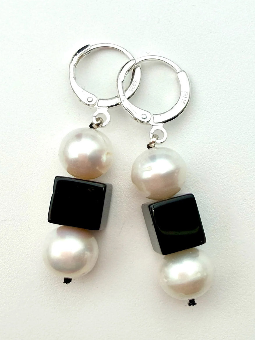 JMNYC Designs Black Onyx Cube With Freshwater Pearls Earrings on Sterling Silver Huggie feature elegant silver hoops, each adorned with two round Freshwater Pearls separated by a striking black onyx cube bead.