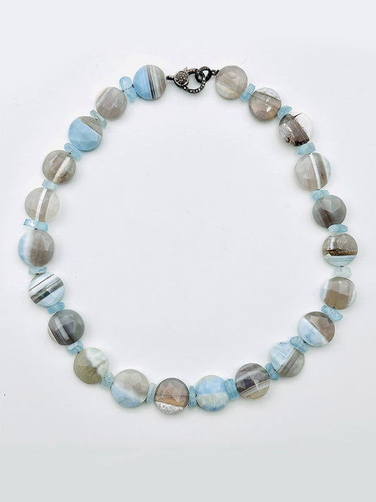 Presenting the JMNYC Designs Coin Blue Boulder Opal Necklace with Aquamarine Slices, featuring round, polished Blue Boulder Opal stones and aquamarine slices in shades of blue, gray, and white, elegantly finished with a sleek sterling silver clasp.