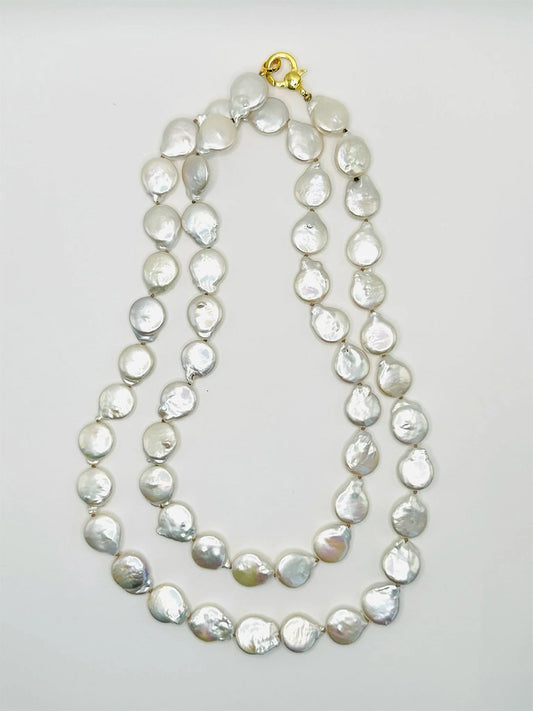 The JMNYC Designs Organic Shaped Freshwater Coin Pearl Necklace 36" showcases flat, round white pearls and a vermeil clasp in a double-strand design, elegantly displayed on a white background.