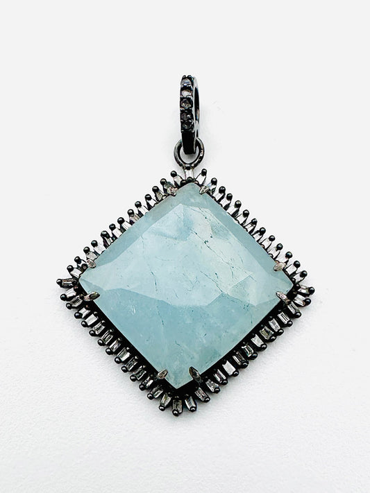 The JMNYC Designs Faceted Aquamarine Sterling Silver Diamond Square Pendant showcases a large, light blue faceted aquamarine gemstone set in a blackened sterling silver square frame accented with sparkling diamond details, all presented against a clean white background.