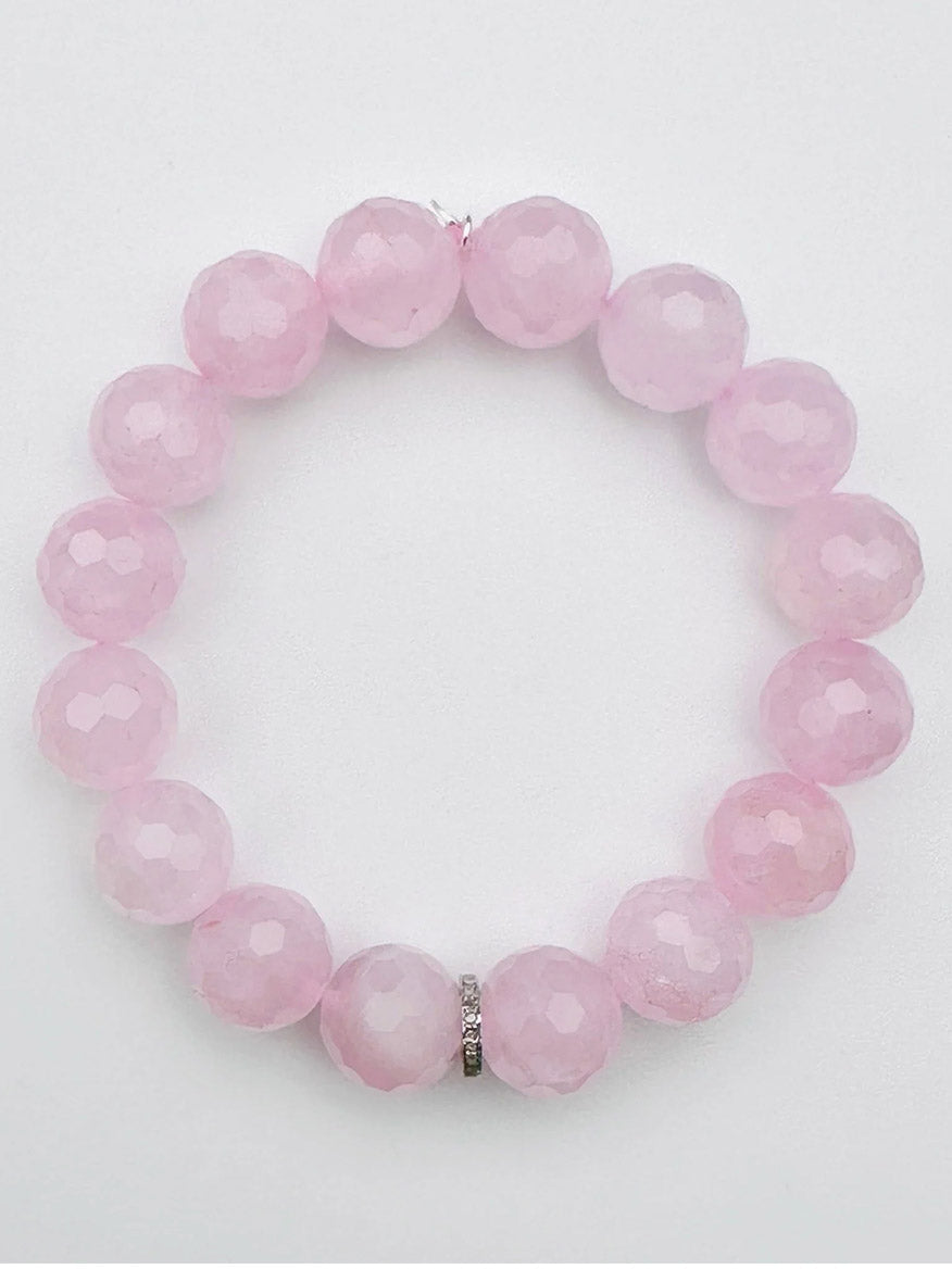 JMNYC Designs Faceted Rose Quartz Ball with Sterling Silver Diamond Rondelle, a limited edition pink beaded bracelet featuring faceted rose quartz and a delicate sterling silver diamond rondelle accent, elegantly arranged in a circle on a plain white background.