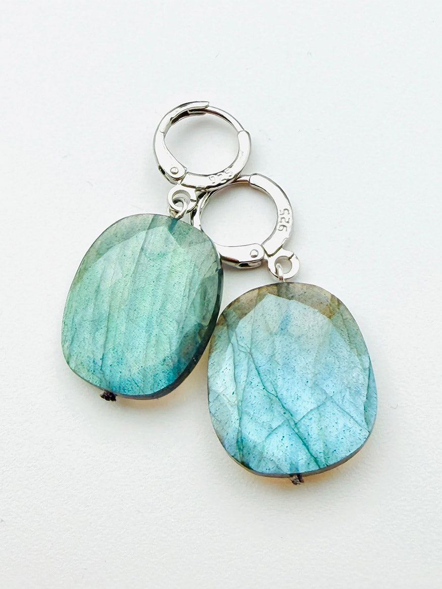 A pair of JMNYC Designs Flat Faceted Labradorite Huggie Earrings in sterling silver with lever-back clasps, displayed on a white background.
