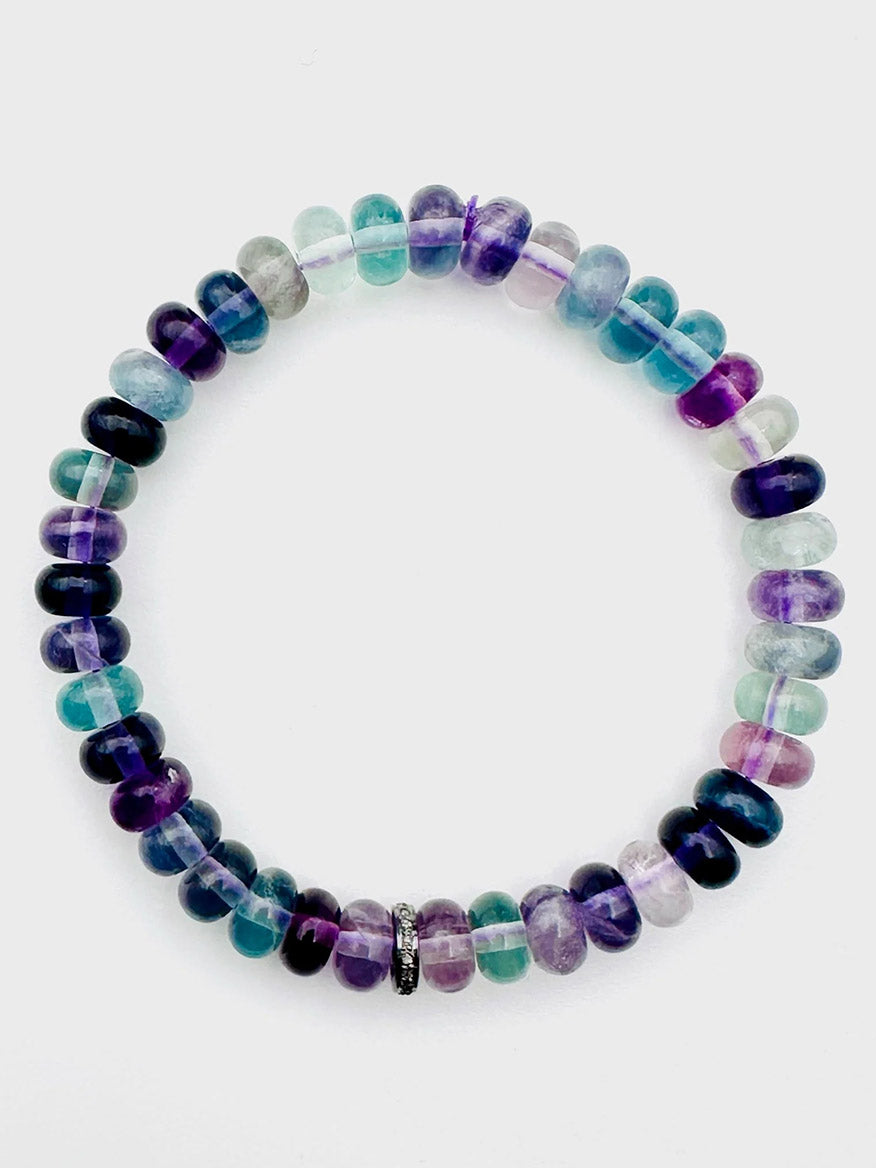 Introducing the JMNYC Designs Smooth Multi-Color Fluorite Rondelle Stretch Bracelet, showcasing vibrant, translucent fluorite rondelles interspersed with a sterling silver and diamond accent bead, elegantly arranged in a perfect circle on a white background.