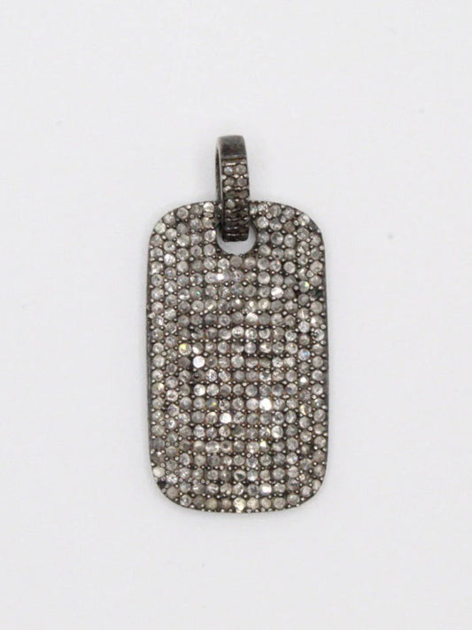 The JMNYC Designs Pave Diamond Dogtag Pendant features a sterling silver rectangular shape with rounded corners, fully encrusted in pave diamonds, and a grooved metal bail for easy chain attachment.