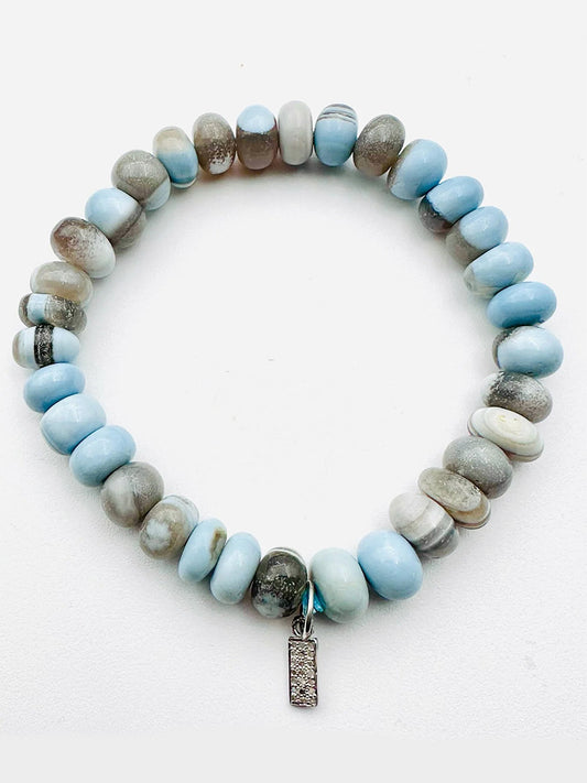 The JMNYC Designs Smooth Peruvian Blue Opal Rondelle Bracelet features blue opal beads and a petite sterling silver diamond dog tag, displayed on a white background.