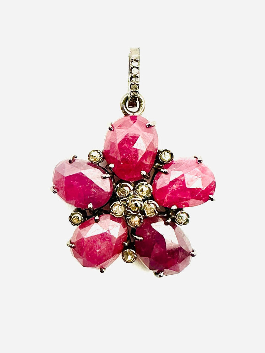 The JMNYC Designs Ruby & Diamond Flower Pendant features five faceted pink rubies as petals and sparkling diamonds at the center, all set in a sterling silver frame.