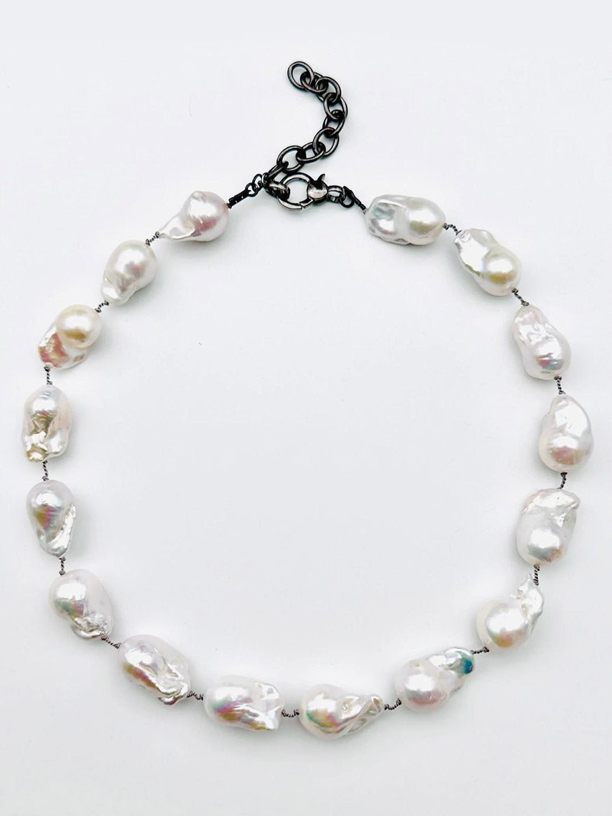 Introducing the JMNYC Designs Silverite Multi Shape Necklace, an elegant 18" piece showcasing uniquely shaped white pearls delicately spaced along a slender strand and completed with a modern black adjustable chain clasp for versatile styling.