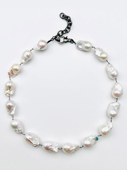 Introducing the JMNYC Designs Silverite Multi Shape Necklace, an elegant 18" piece showcasing uniquely shaped white pearls delicately spaced along a slender strand and completed with a modern black adjustable chain clasp for versatile styling.
