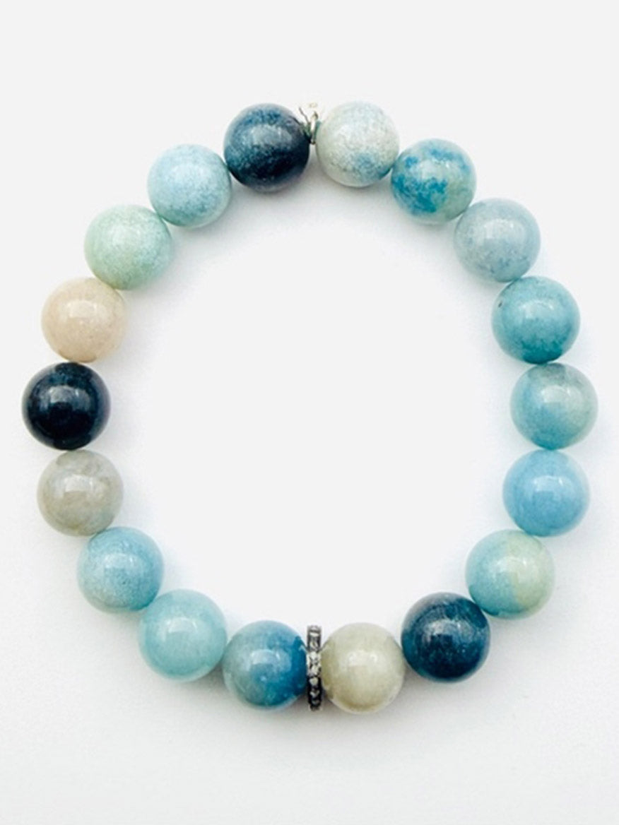 The JMNYC Designs Trolleite Ball Stretch Bracelet with Sterling Silver Diamond Rondelle showcases polished round blue, turquoise, and beige trolleite stones arranged in a circular design, accented with a sparkling sterling silver diamond rondelle. This elegant stretch bracelet effortlessly combines comfort and sophistication for everyday wear.