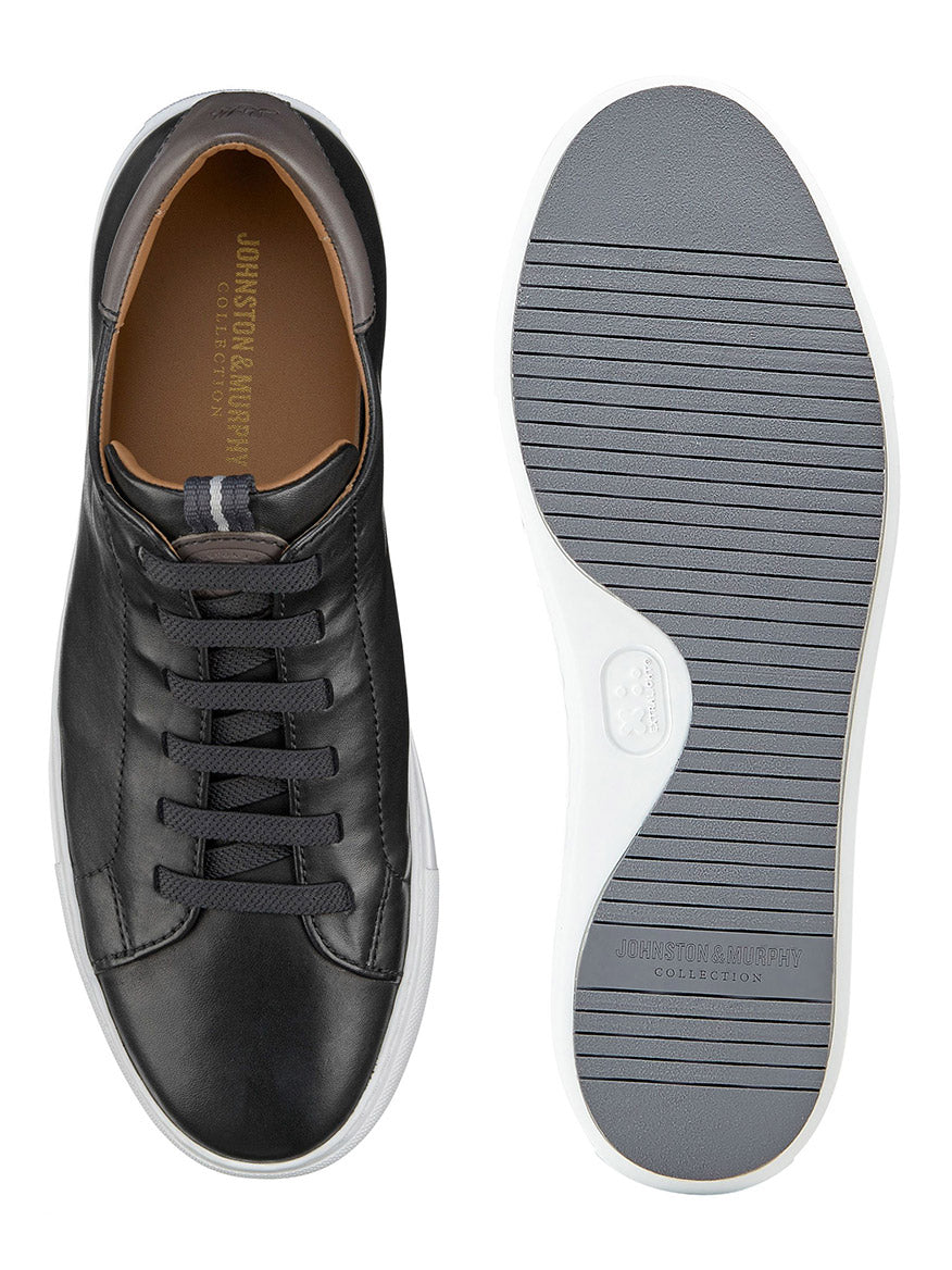 Introducing the J & M Collection Anson Lace-to-Toe in Black Sheepskin: a pair of sneakers meticulously crafted from premium leather. These shoes feature modern cushioning for enhanced comfort. One shoe presents the top view with elegant laces, while the other showcases the grooved EVA outsole. The brand is subtly embossed inside, adding a touch of refinement to this sophisticated pair.