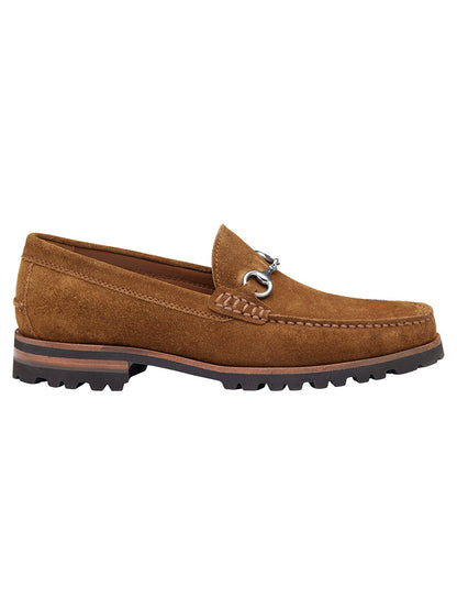 The J & M Collection Baldwin Lug Bit in Snuff English Suede is a brown suede loafer featuring a sleek silver buckle and a thick, treaded EVA lug outsole, highlighting its moccasin construction from the side.