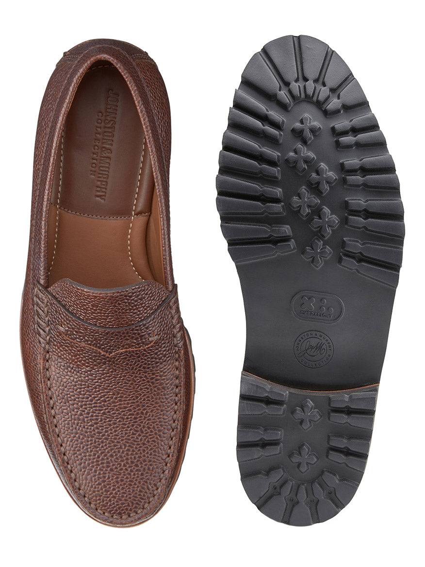 The J & M Collection Baldwin Lug Penny in Mahogany Scotch Grain features textured uppers and treaded rubber soles, with views from top and bottom. Its cushioned footbed ensures all-day comfort, while the handsewn moccasin design blends traditional craftsmanship with modern style.