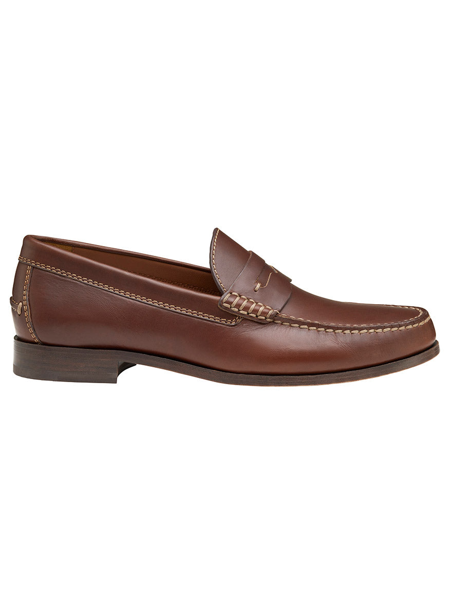 A side view of a J & M Collection Baldwin Penny in Brandy American Full Grain leather loafer with detailed stitching and a low wooden heel, showcasing its impeccable leather construction.