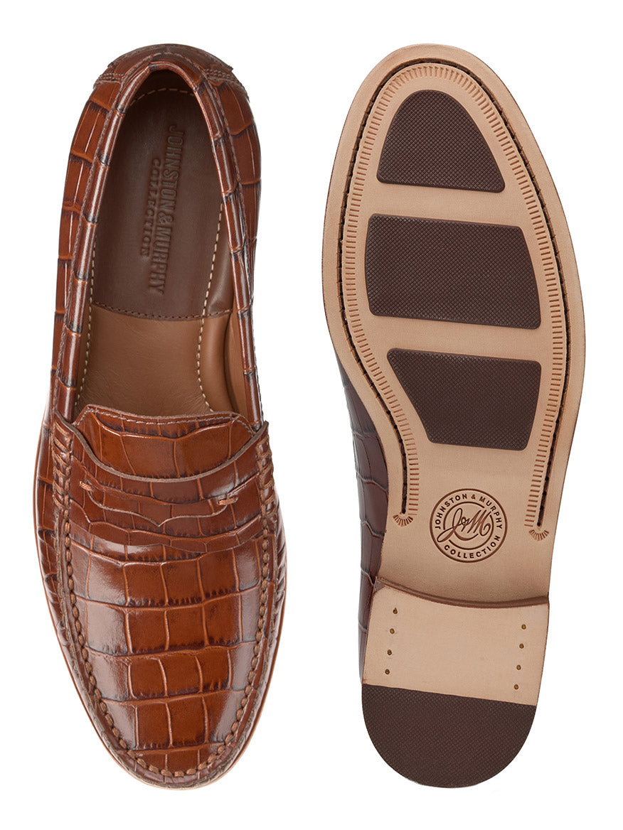 The J & M Collection Baldwin Penny in Mahogany Croc Print Calfskin is displayed from top and bottom views. The handsewn moccasin construction enhances durability, while the outsole features a non-slip design. The branded insole and luxurious Italian calfskin upper add an element of sophistication.