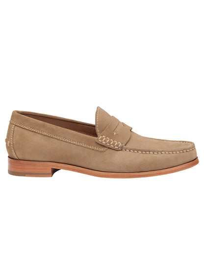 A single J & M Collection Baldwin Penny in Taupe English Suede with visible stitching, a slight heel, and a decorative strap across the upper part of the shoe. This handsewn moccasin features water-resistant suede, ensuring durability and style.