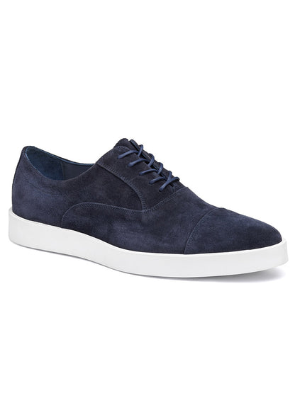 The J & M Collection Bolivar Cap in Navy Italian Suede is a men's shoe featuring blue laces, a white rubber sole, and full leather lining for added comfort.