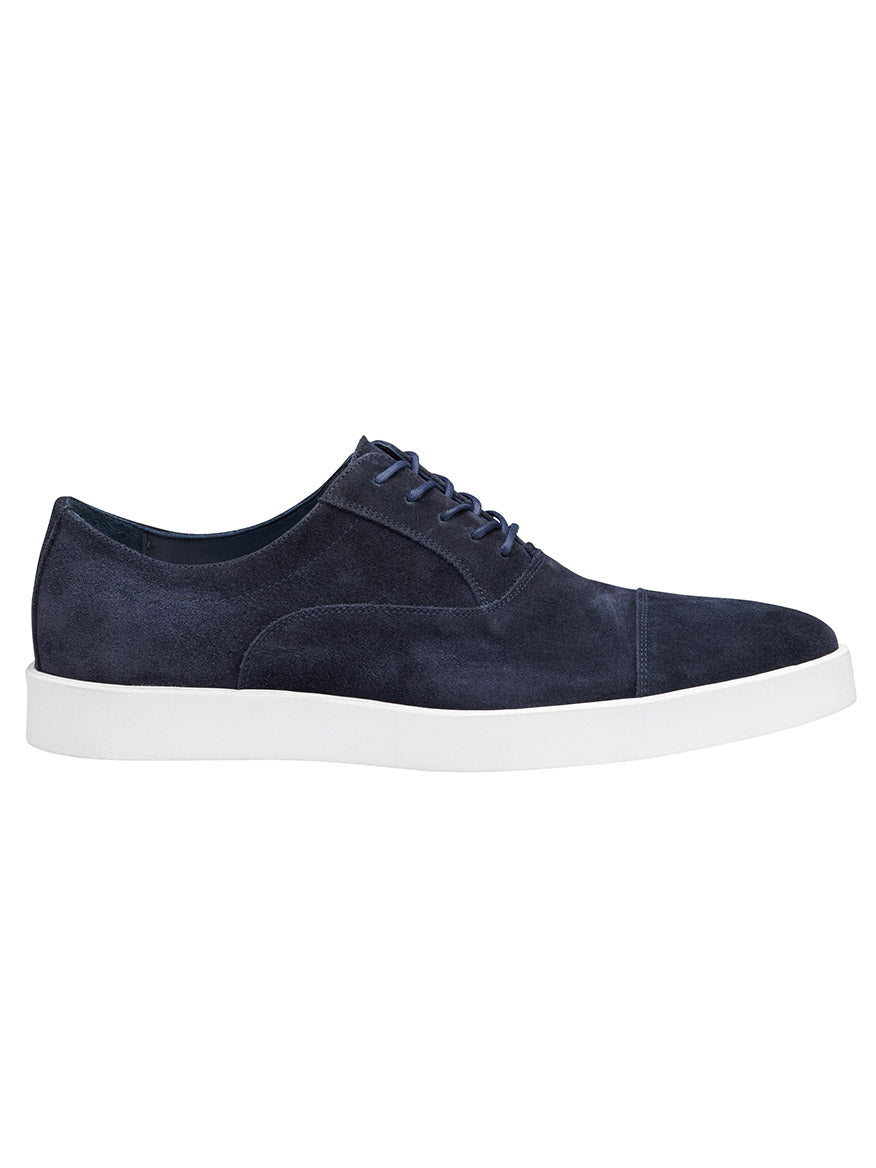 The J & M Collection Bolivar Cap in navy Italian suede is a men's shoe featuring blue laces, white rubber soles, and a fully leather-lined interior for added luxury.