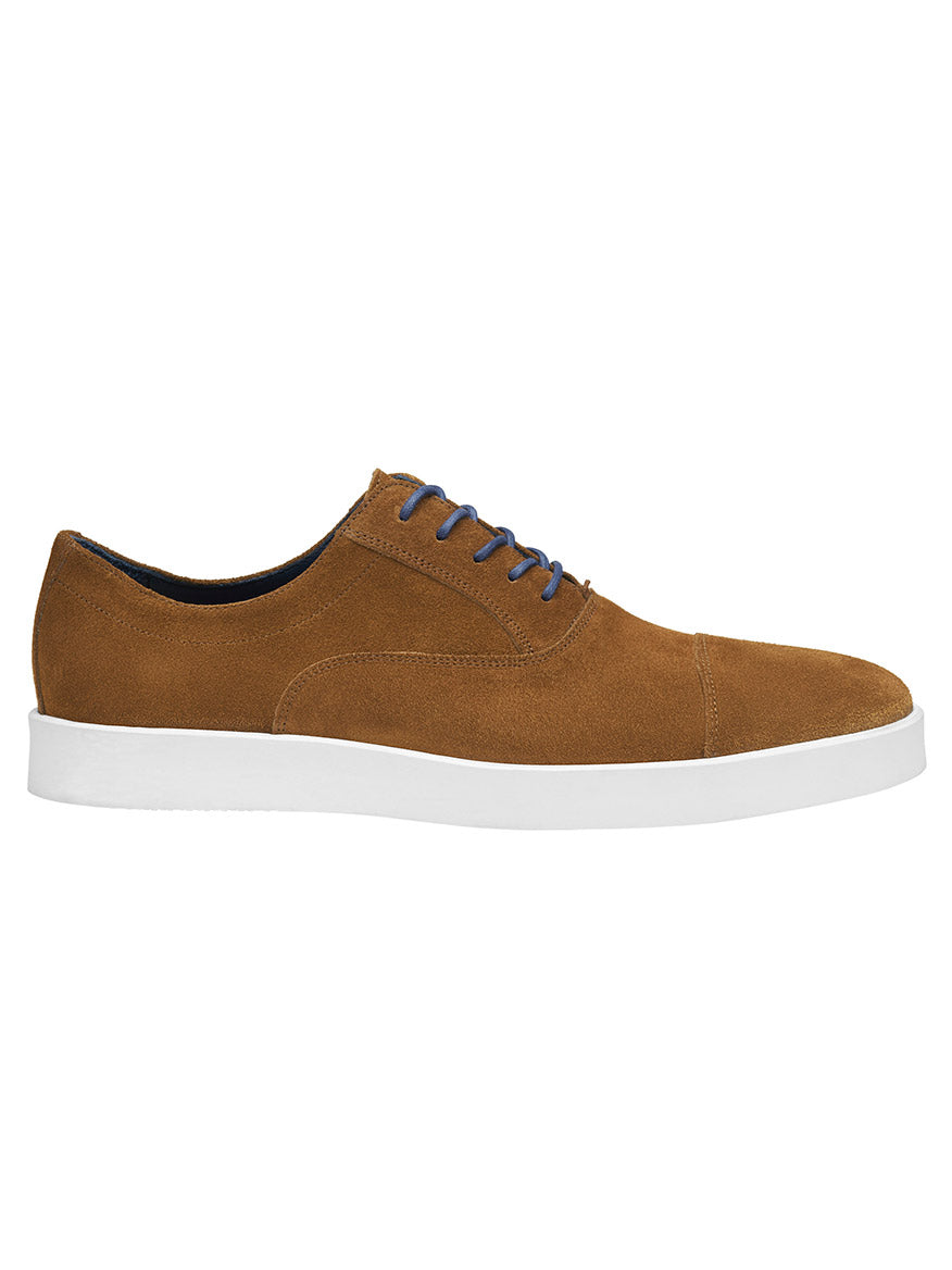 The J & M Collection Bolivar Cap Toe in Snuff Italian Suede is a brown casual sneaker crafted from luxurious Italian suede, featuring a white rubber sole, blue laces, and full leather lining for added comfort.