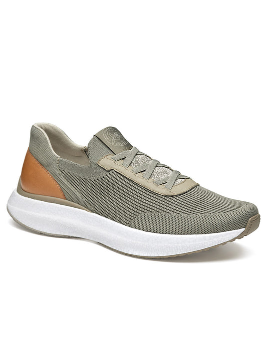 The J & M Collection Briley Knit Jogger in Taupe Knit features a green-colored athletic shoe with a white sole and tan accent on the heel. It comes with a lace-up closure, textured knit upper for enhanced breathability, and includes a removable EVA footbed for customized comfort.