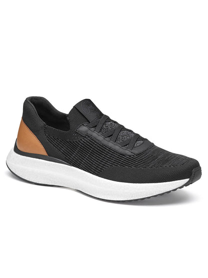 The J & M Collection Briley Knit Jogger in Black Knit is a black athletic shoe with a white sole and brown detail on the heel, featuring knit uppers, a lace-up design, and a POWERFOAM midsole for optimal comfort.