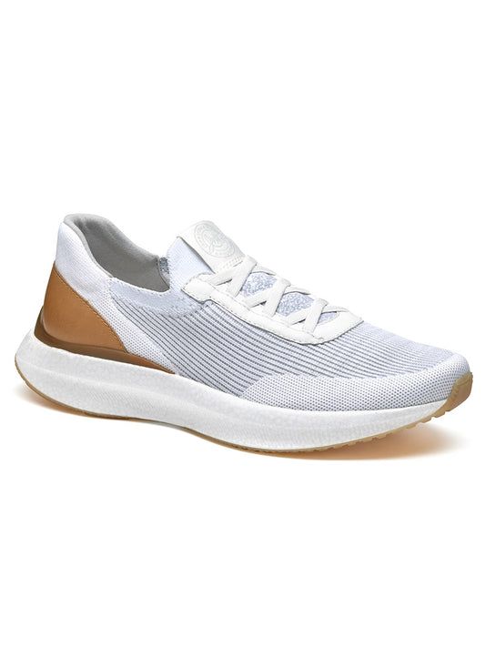 The J & M Collection Briley Knit Jogger in White Knit is an athletic shoe featuring a lace-up design, white knit uppers with tan accents, and a white sole. It also includes a memory-foam footbed for enhanced comfort.