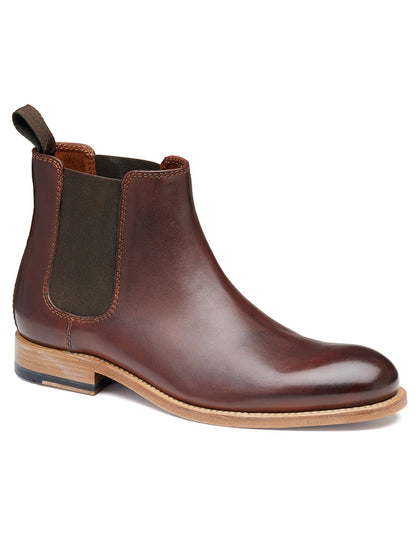 The J & M Collection Dudley Chelsea Boot in Mahogany Dip-Dyed Calfskin, a luxurious boot featuring an elastic side panel, a wooden sole, and Goodyear welt construction, is displayed against a white background.